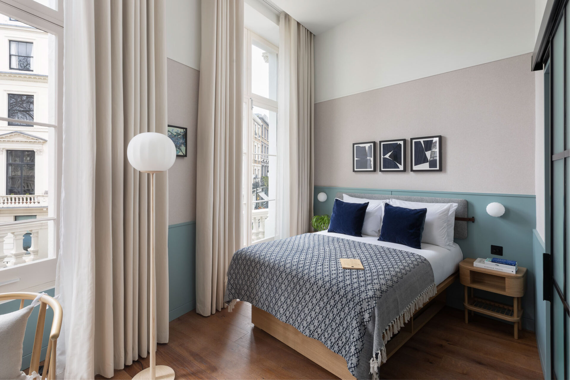 large hotel bedroom with blue walls and navy cushions